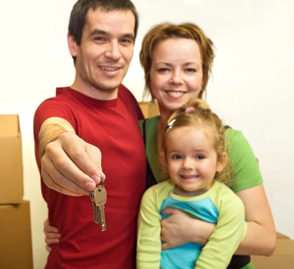 Οικογένεια στο νέο σπίτι τους - που δείχνει το κλειδί — Φωτογραφία Αρχείου