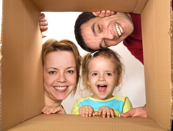 Family opening cardboard box - happy moving concept — Stock Photo, Image