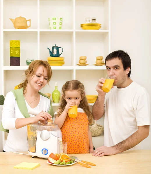 Familie maken en vers vruchtensap drinken — Stockfoto