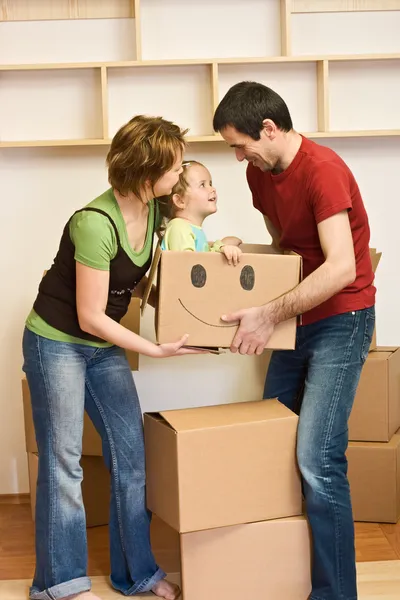 Família feliz com uma criança se mudando para uma nova casa — Fotografia de Stock