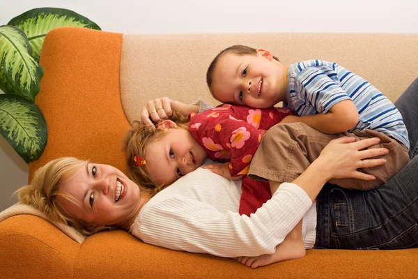 Šťastná žena a děti baví interiéru — Stock fotografie