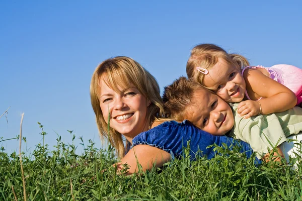 Mulher e seus filhos brincando ao ar livre — Fotografia de Stock