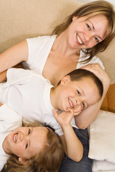 Donna e bambini sul divano — Foto Stock