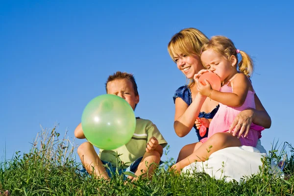 Mulher e crianças brincando com balões — Fotografia de Stock
