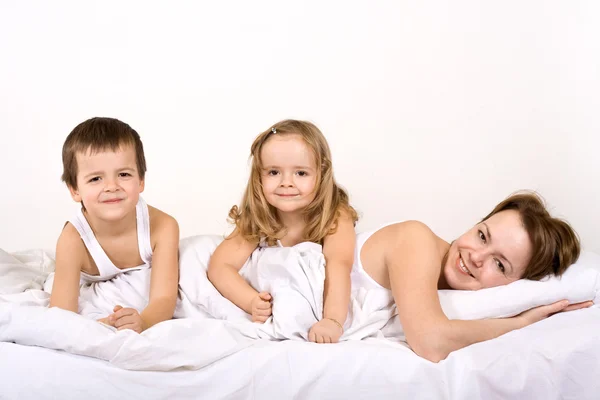 Happy posing for a family portrait in bed — Stock fotografie