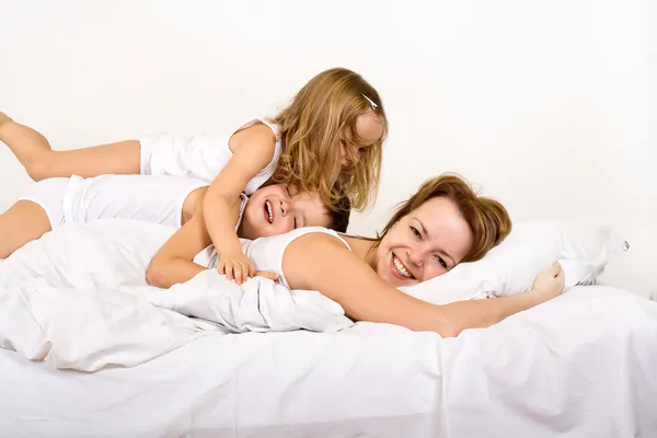 Buon giorno - donna e bambini sul letto — Foto Stock