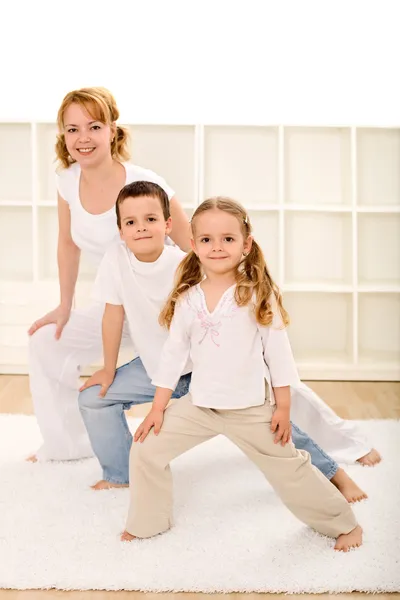 Happy kids and woman doing gym exercises — Stock Photo, Image