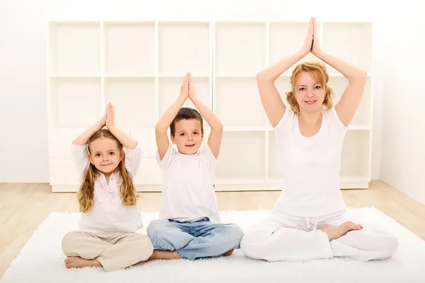 Familia haciendo ejercicios de yoga —  Fotos de Stock