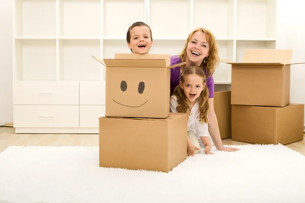 Crianças felizes e mulher se divertindo em sua nova casa — Fotografia de Stock