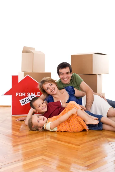 Happy family laying on the floor of their new home — Stock Photo, Image