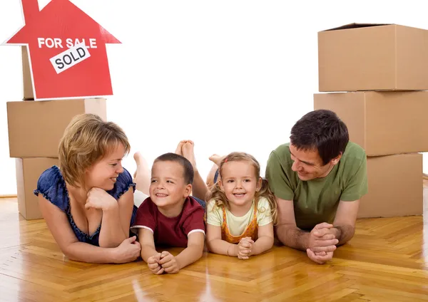Šťastná rodina s dvěma dětmi v jejich novém domově — Stock fotografie