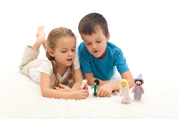 Kids playing with puppets laying on the floor Stock Photo