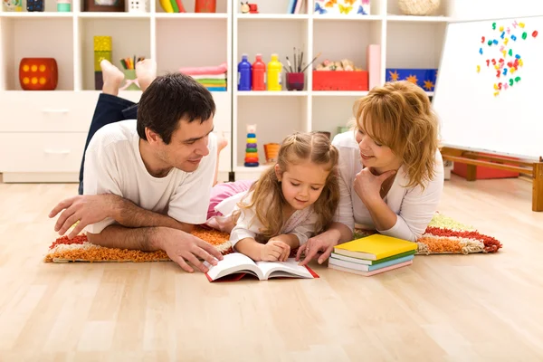 Lycklig familj läsning i barntyger Stockbild
