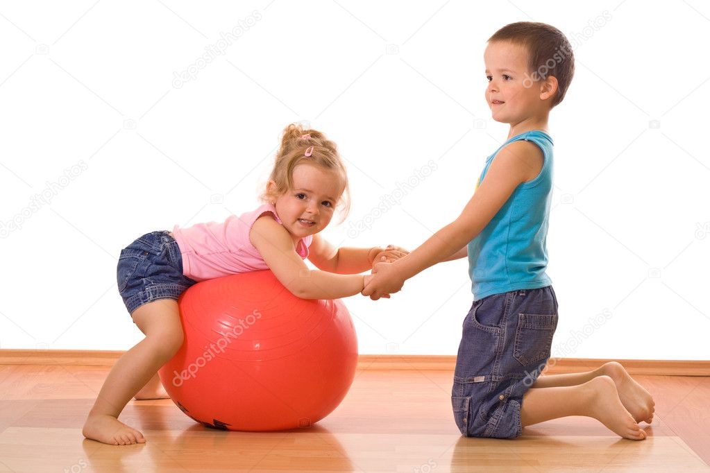 Little boy teaching her sister gymnastics