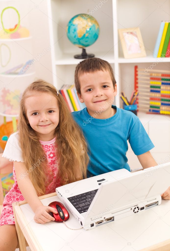 Siblings with laptop computer in their room