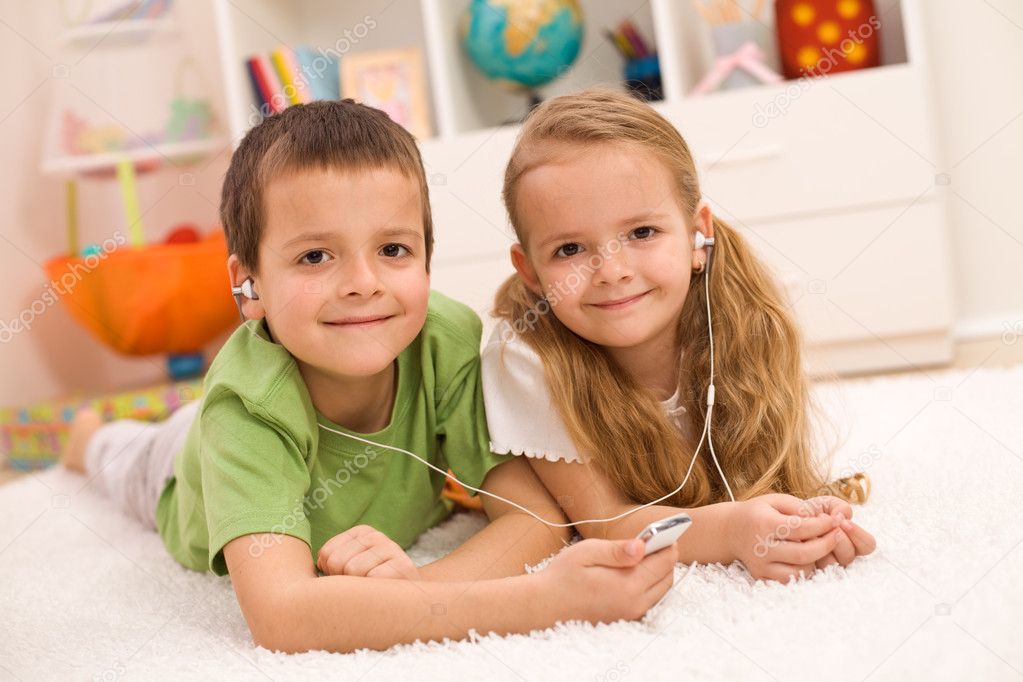 Little boy and girl listening to music together