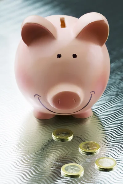 Happy piggy bank and golden euro coins — Stock Photo, Image