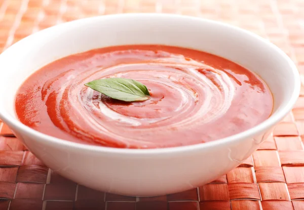 Sopa de tomate cremosa com folhas de manjericão como guarnição — Fotografia de Stock