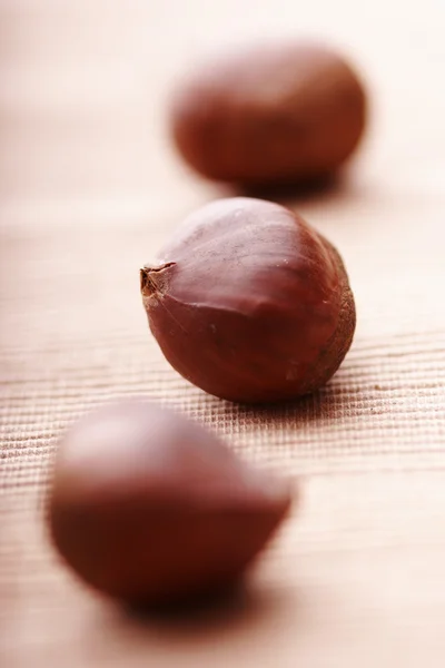 Chestnuts lined up on cloth, focus on the middle one — Stock Photo, Image