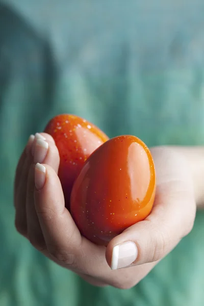Mão com dois ovos de Páscoa vermelhos — Fotografia de Stock