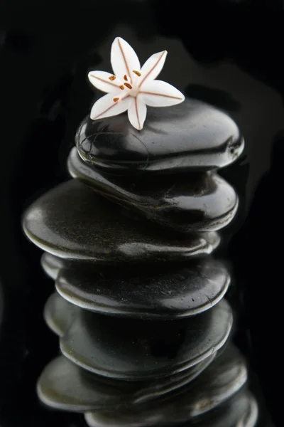 Stack of black rocks on mirror — Stock Photo, Image