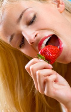 Young beautiful happy smiling woman with strawberry on sea beach