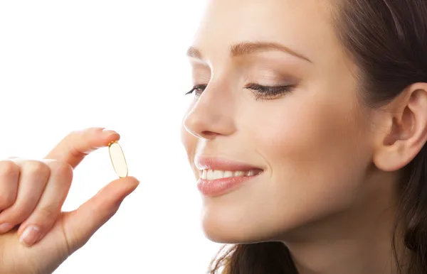 Portrait of woman with Omega 3 fish oil capsule, isolated on whi — Stock Photo, Image