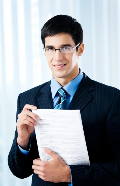 Glücklich lächelnder Geschäftsmann zeigt Dokument oder Vertrag, zumindest — Stockfoto