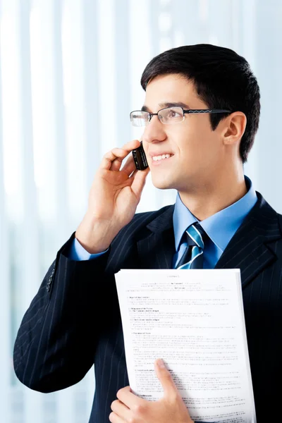 Gelukkig lachend zakenman weergeven met document of contract, bij het kantoor — Stockfoto