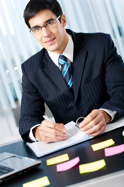 Portret uśmiechający się biznesmen pisanie pracy w biurze — Zdjęcie stockowe