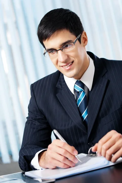 Portret uśmiechający się biznesmen pisanie pracy w biurze — Zdjęcie stockowe