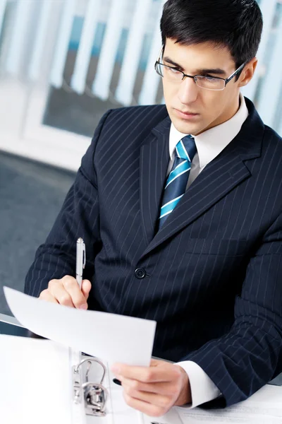 Portrait of reading businessman working at office — Stock Photo, Image
