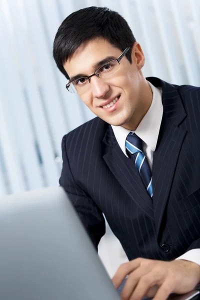 Framgångsrik affärsman med laptop på kontoret — Stockfoto