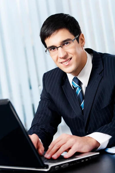 Framgångsrik glada leende affärsman arbetar med laptop på offi — Stockfoto