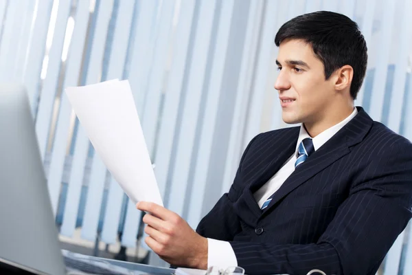 Affärsman med dokument och laptop på kontoret — Stockfoto