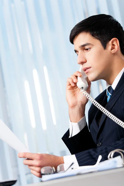 Hombre de negocios exitoso con teléfono y documento en la oficina — Foto de Stock