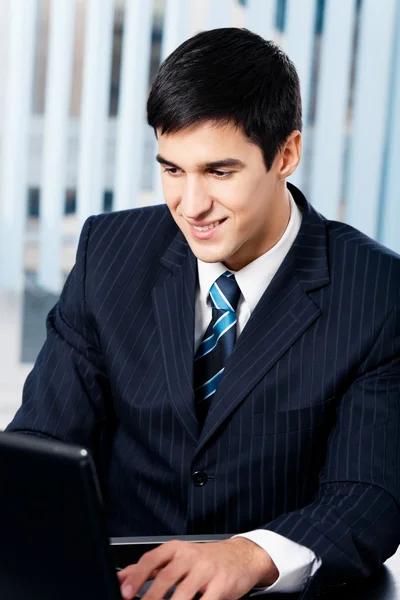 Succès heureux souriant homme d'affaires travaillant avec ordinateur portable à offi — Photo
