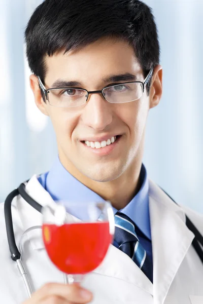 stock image Happy smiling doctor with red wine, at office