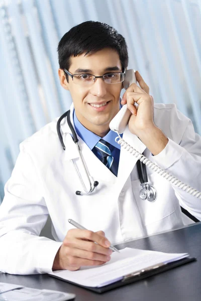 Успішний лікар з телефоном, на робочому місці — стокове фото