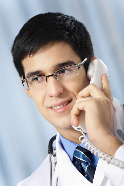 Успешный врач по телефону, на рабочем месте — стоковое фото