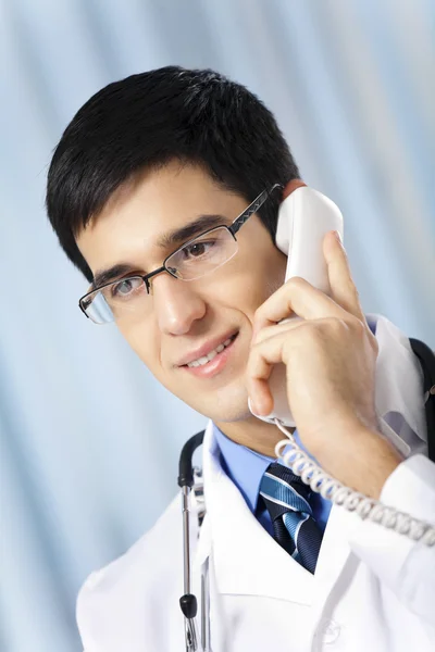 Médico exitoso con teléfono, en el lugar de trabajo —  Fotos de Stock
