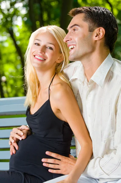 Щаслива красива вагітна жінка і її чоловік, на відкритому повітрі — стокове фото