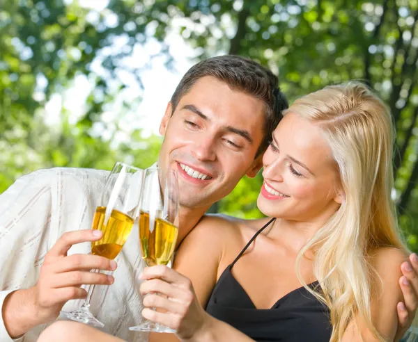 Молода щаслива пара святкує з шампанським, на відкритому повітрі — стокове фото
