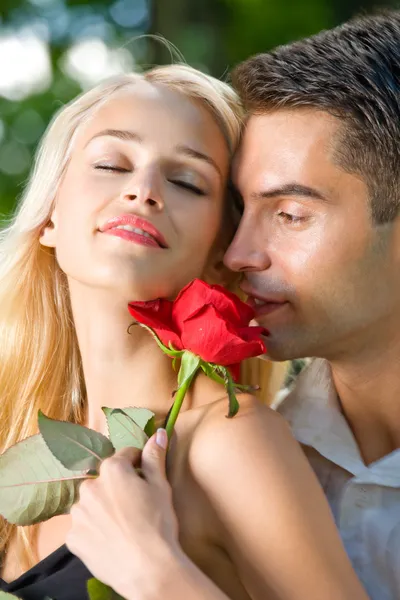 Portarit de jovem feliz casal amoroso com rosa, ao ar livre — Fotografia de Stock
