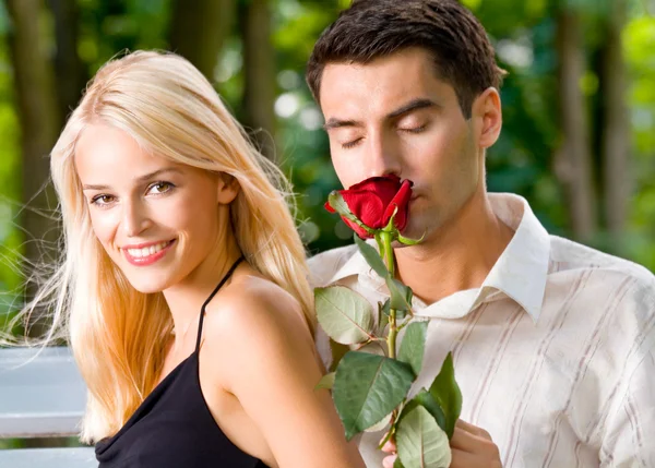Divertida joven feliz pareja con rosa, al aire libre —  Fotos de Stock