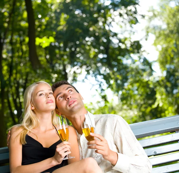 Casal jovem comemorando com champanhe ao ar livre. Para fornecer o máximo — Fotografia de Stock