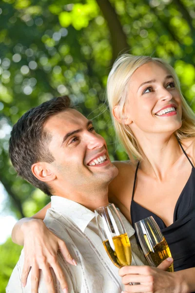 Jonge gelukkige paar vieren met de champagne, buitenshuis — Stockfoto