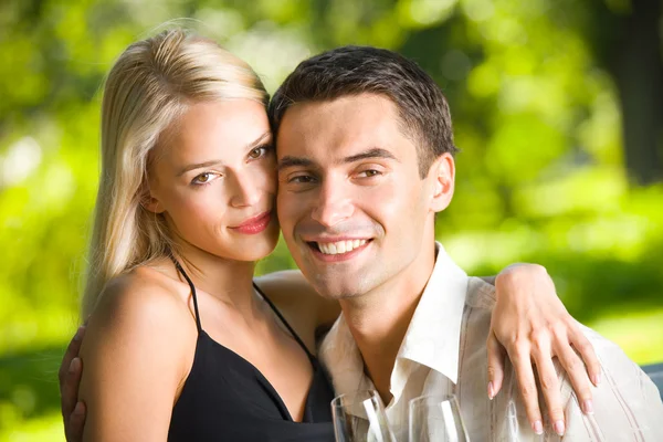 Jeune couple célébrant avec du champagne ensemble, en plein air — Photo