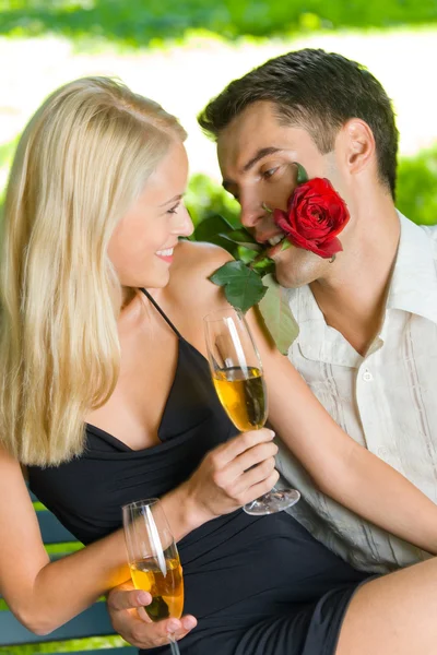 Roliga unga lyckliga paret med present och rosa, utomhus — Stockfoto
