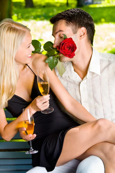 Cena engraçada de casal comemorando com champanhe e rosa, outdo — Fotografia de Stock